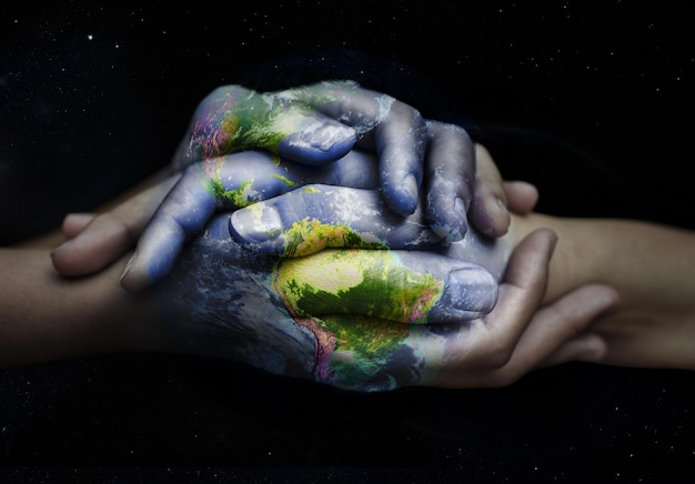 Superposition de la Terre tenant la main et soutien à la durabilité des personnes ayant un amour et une empathie mondiaux Vert durable et mains ensemble pour une aide internationale confiance écologique et aide à l'écologie