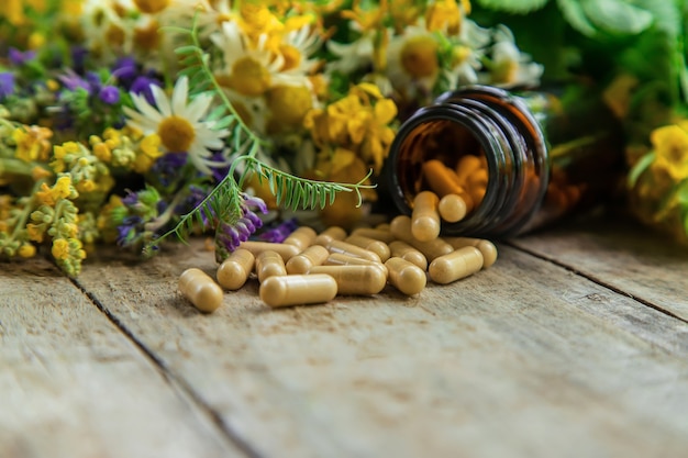 suppléments, vitamines et herbes médicinales dans des bocaux en verre sur une table en bois