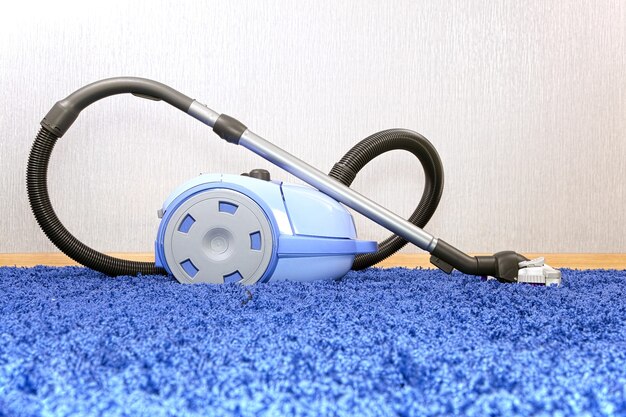 Photo support d'aspirateur puissant sur tapis bleu.