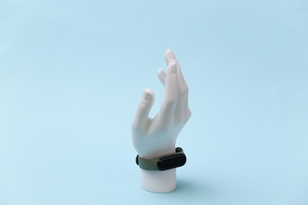 Support de mannequin blanc avec bracelet intelligent sur fond bleu. Gadgets modernes