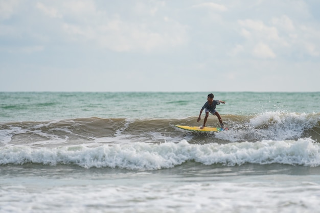 Un avec un surf dans ses mains au bord de la mer