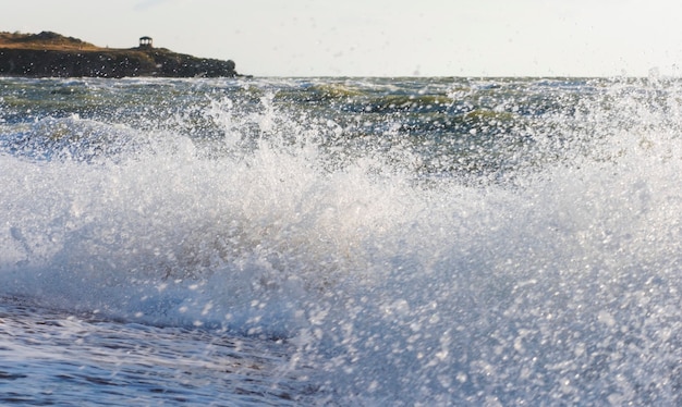 Surf de mer grande vague sur la côte et le cap avec pavillon à distance