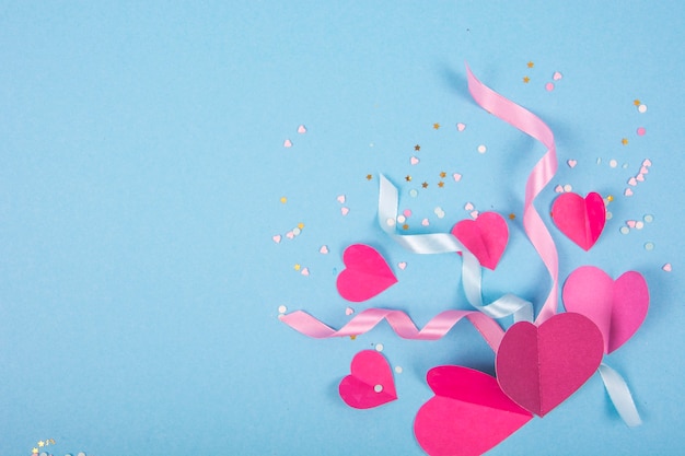 Surface abstraite avec des coeurs en papier, des rubans pour la Saint-Valentin