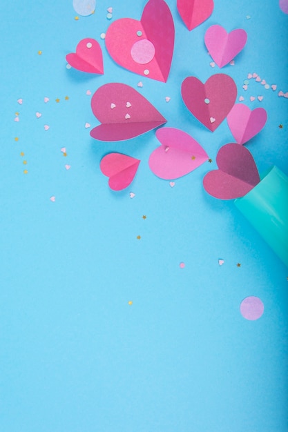 Surface abstraite avec des coeurs en papier, verre de champagne bleu pour la Saint-Valentin