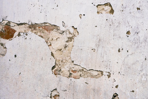 Surface en béton fissuré Arrière-plan ou texture d'un mur de plâtre en brique de ciment rétro avec des fissures