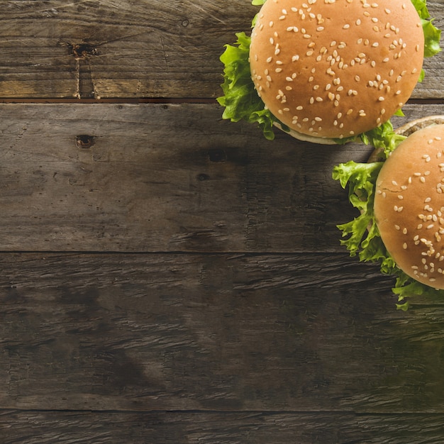 Photo surface en bois avec deux hamburgers et espace vide