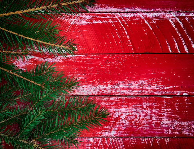 Surface en bois rouge vintage avec branche de sapin