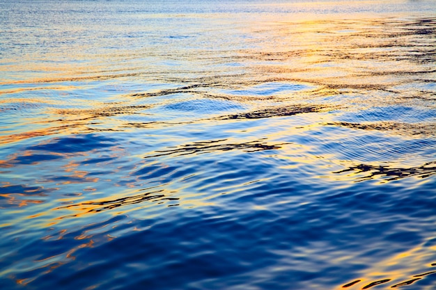 Surface colorée de l'eau de mer au coucher du soleil - abstrait