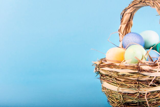 Surface colorée avec des oeufs de Pâques sur une surface bleue