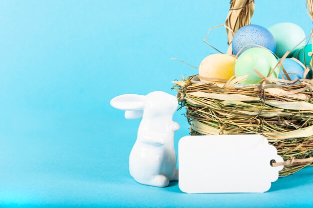 Surface colorée avec des oeufs de Pâques sur une surface bleue