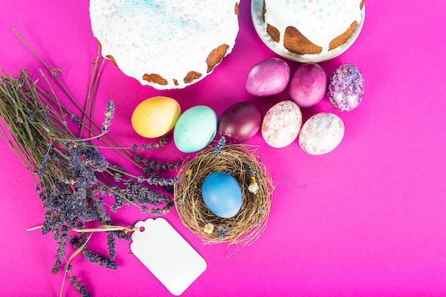 Surface colorée avec des oeufs de Pâques sur une surface rose