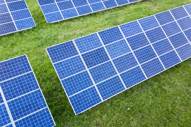 Surface du système de panneaux photovoltaïques solaires produisant de l'énergie propre renouvelable sur l'herbe verte