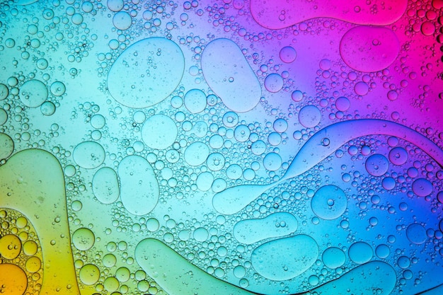 Surface de l'eau colorée avec des gouttes d'huile flottantes