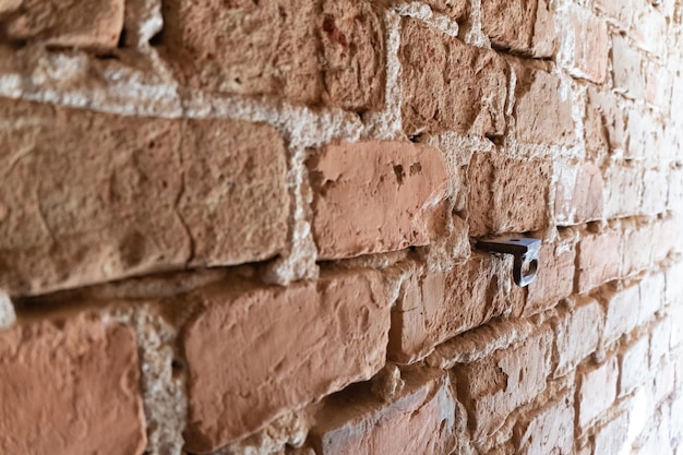 La surface est faite de vieilles briques rouges Un mur de vieilles connaissances historiques et de briques cassées et cassées et de broches métalliques saillantes Fond blanc pour la conception