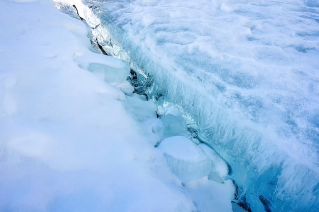 Surface fissurée du lac gelé en hiver