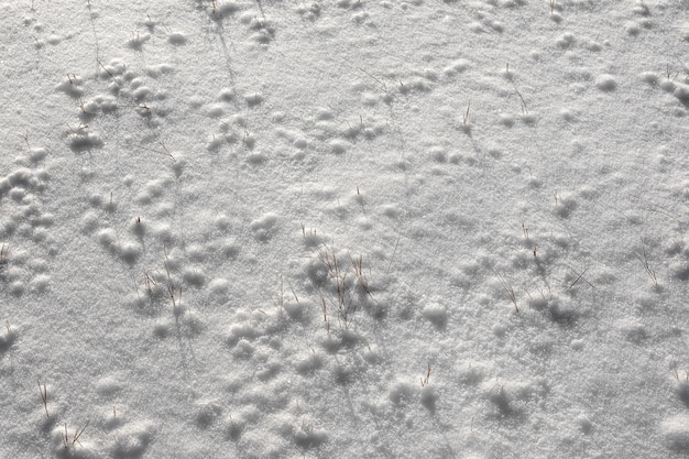 La surface inégale de la neige tombée sur le terrain. Couleur et texture naturelles de la neige