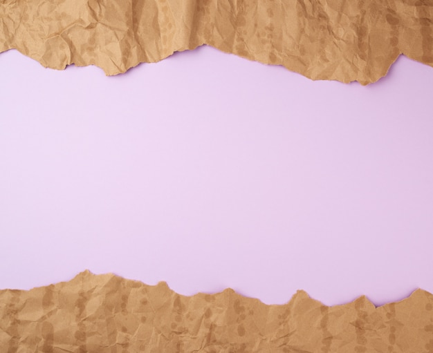 Surface lilas avec des éléments en papier déchiré brun