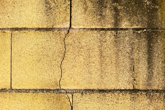 Surface d&#39;un mur jaune fissuré