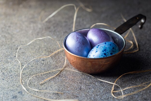 Surface de Pâques avec des oeufs de Pâques peints dans un style vintage sur une surface sombre