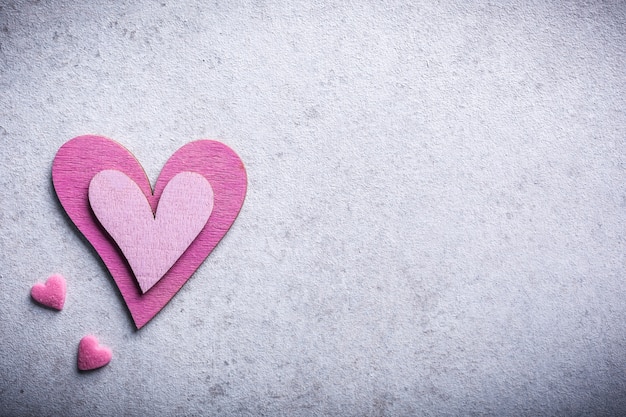 Surface de la Saint-Valentin avec coeur en bois rose décoratif sur pierre de béton avec espace de copie pour le texte. Concept de la Saint-Valentin. Vue d'en-haut