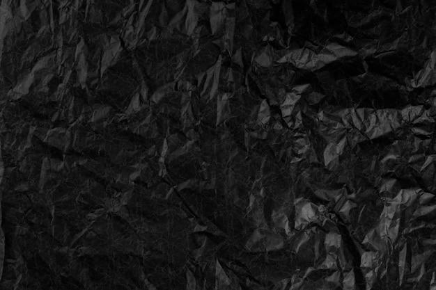 surface avec une texture de papier noir froissé.