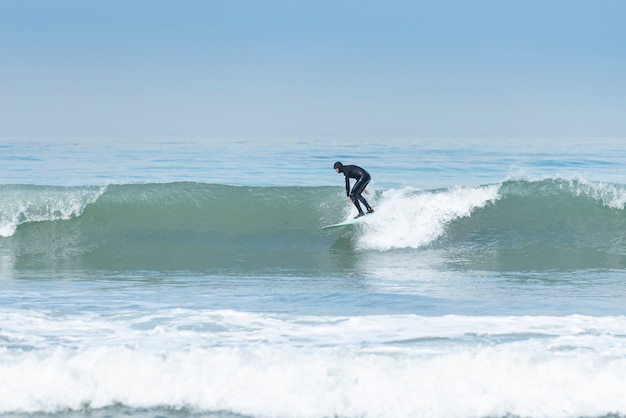 Photo surfeur en action homme surfant sur la vague