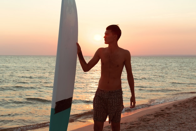 Un surfeur au coucher du soleil.