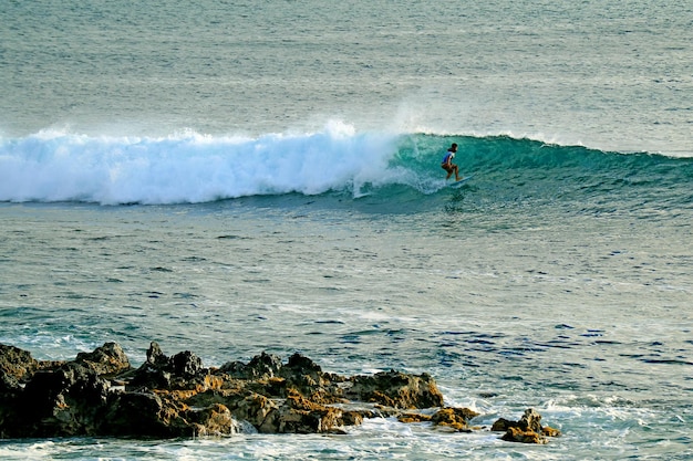 Surfeur à cheval sur les grosses vagues de l'océan Pacifique à la ville de Hanga Roa de l'île de Pâques Chili