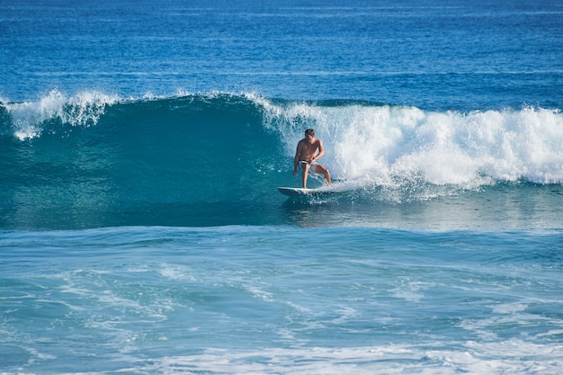 Le surfeur chevauche une belle et grande vague vitreuse