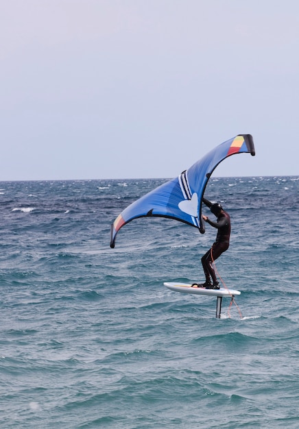 surfeur en windfoil naviguant à travers les vagues