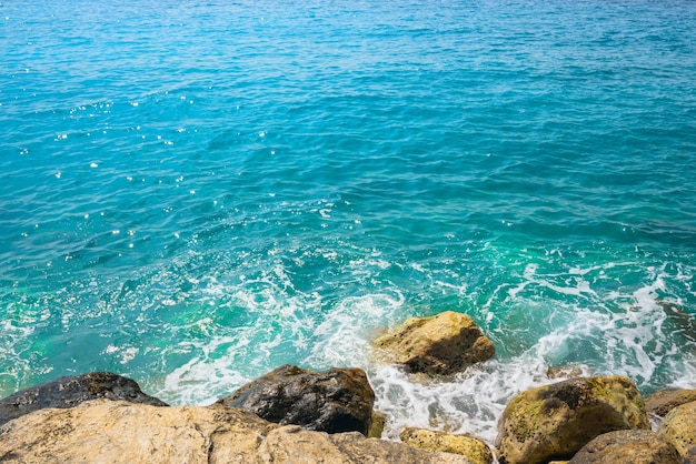 Surfez sur le rivage rocheux de la mer bleue journée ensoleillée