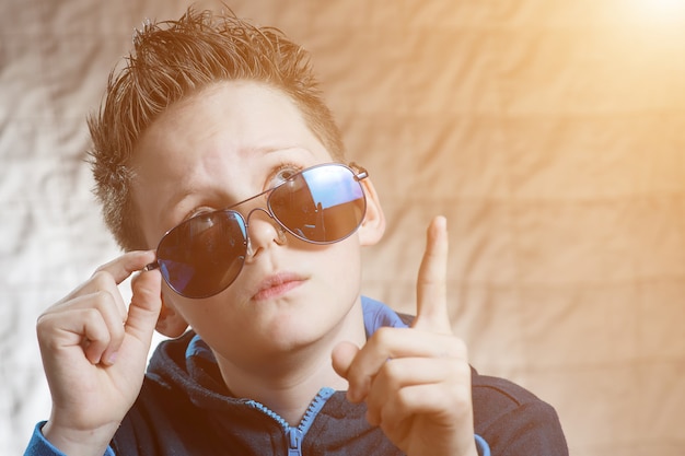 Surpris adolescent garçon à lunettes de soleil