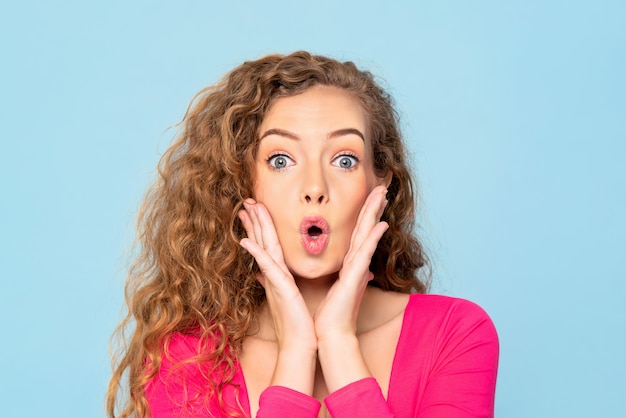 Surpris Choqué Femme Caucasienne Avec Les Yeux éclatés Et Les Mains Sur Les Joues Dans Le Mur Bleu