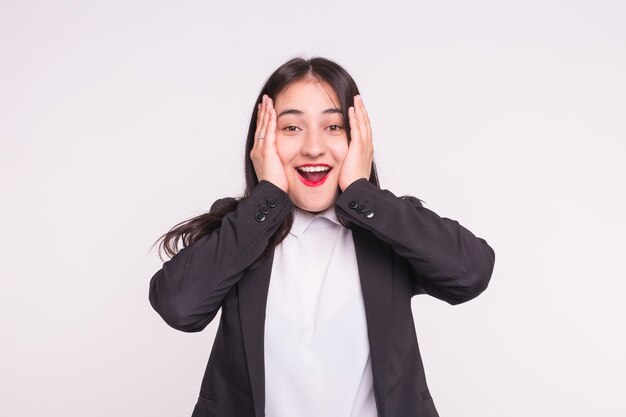 Surpris jeune femme asiatique avec des lèvres rouges portant un costume noir sur blanc.