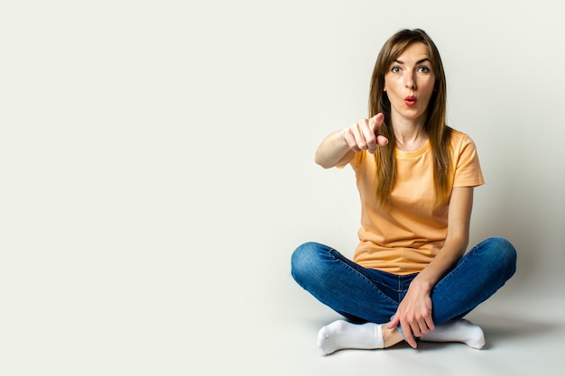 Surpris de jeune femme assise sur le sol