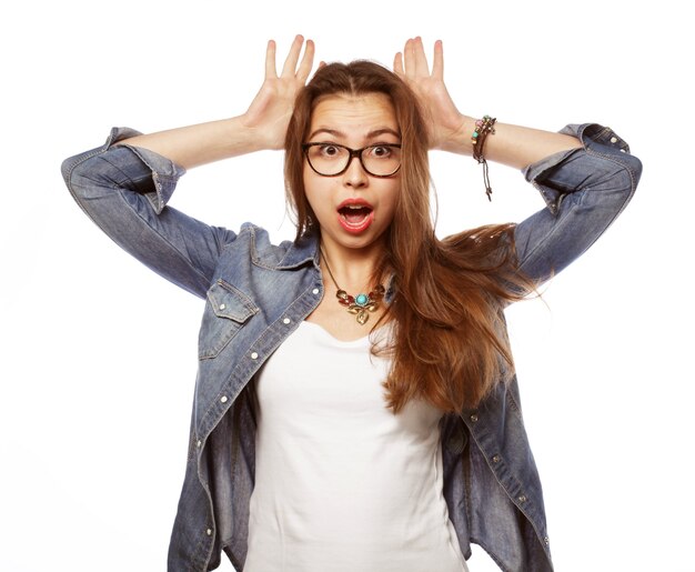 Surpris jeune femme brune à lunettes sur blanc