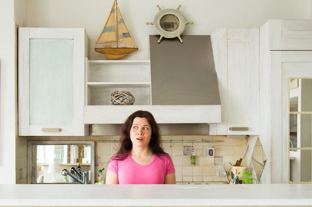 Surpris jeune femme dans la cuisine à la maison