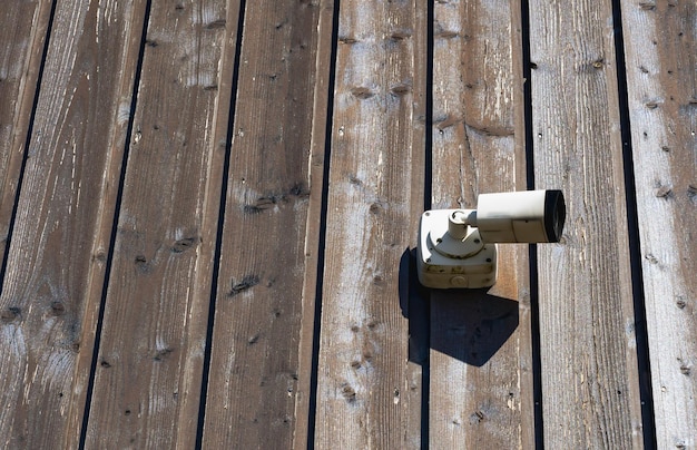 Surveillant sur la caméra de sécurité de rue sur le mur en bois