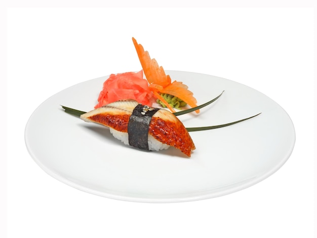 Sushi à l'anguille et gingembre mariné et wasabi sur une assiette ronde blanche