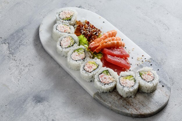 Sushi sur assiette servi avec crevettes et sashimi