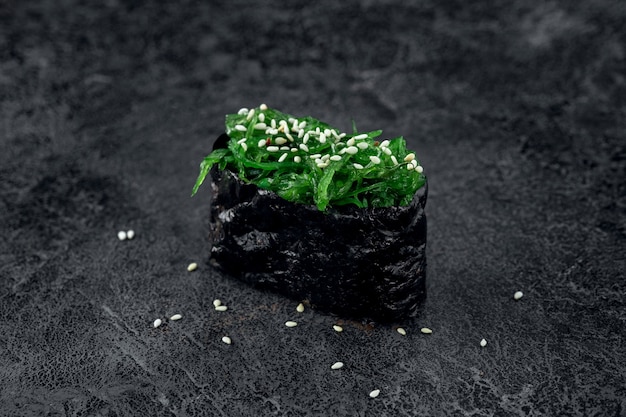 Sushi aux algues et graines de sésame sur fond de pierre. Plat japonais chuka sushi, gros plan