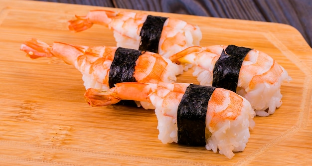 Sushi aux crevettes sur un support en bois.