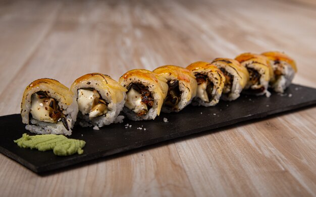 Sushi Board japonais, fromage de chèvre Urimaki et pomme sur fond de bois.