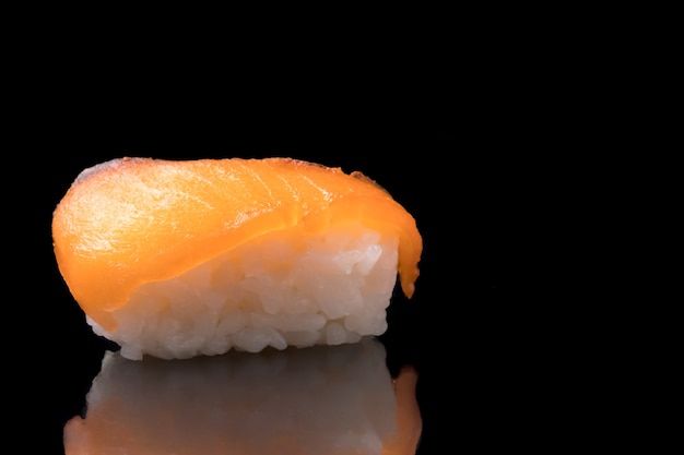 Sushi, cuisine japonaise, riz au saumon sur fond noir.