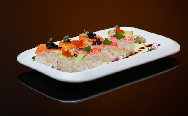 Sushi dans une assiette sur fond marron avec reflet. rouleau de poisson