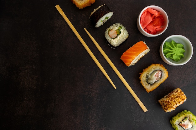 Sushi de différents types sur une vue de dessus de fond sombre, avec place pour le texteSushi de différents types sur une vue de dessus de fond sombre, avec place pour le texte