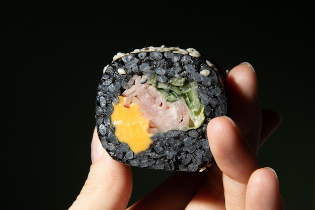Sushi sur fond vert dans une main