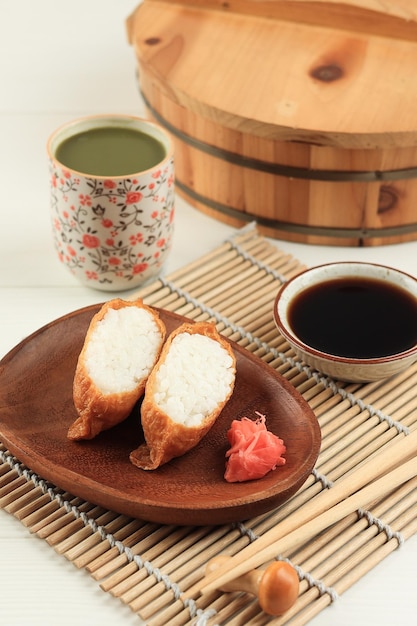 Sushi japonais au tofu de poche ou sushi Inari servi avec du lait matcha