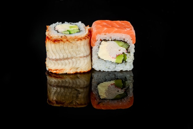 Sushi japonais frais traditionnel roule sur un fond noir