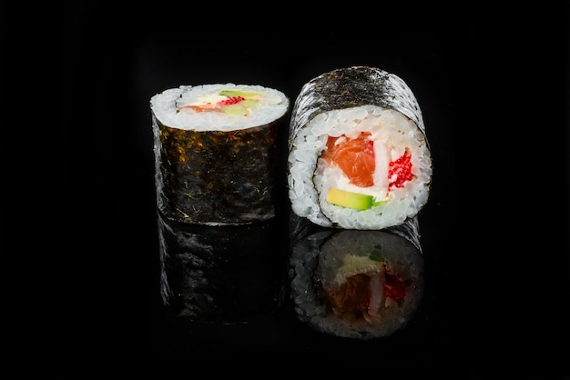 Sushi japonais frais traditionnel roule sur un fond noir